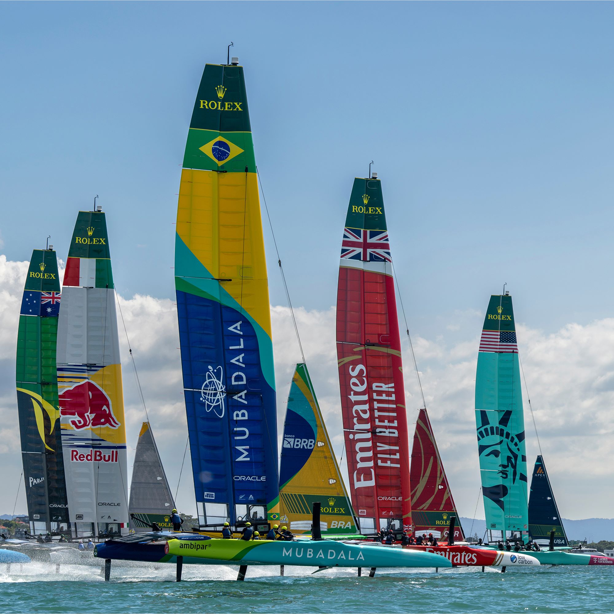 Catamarans race across the water on a sunny day. 